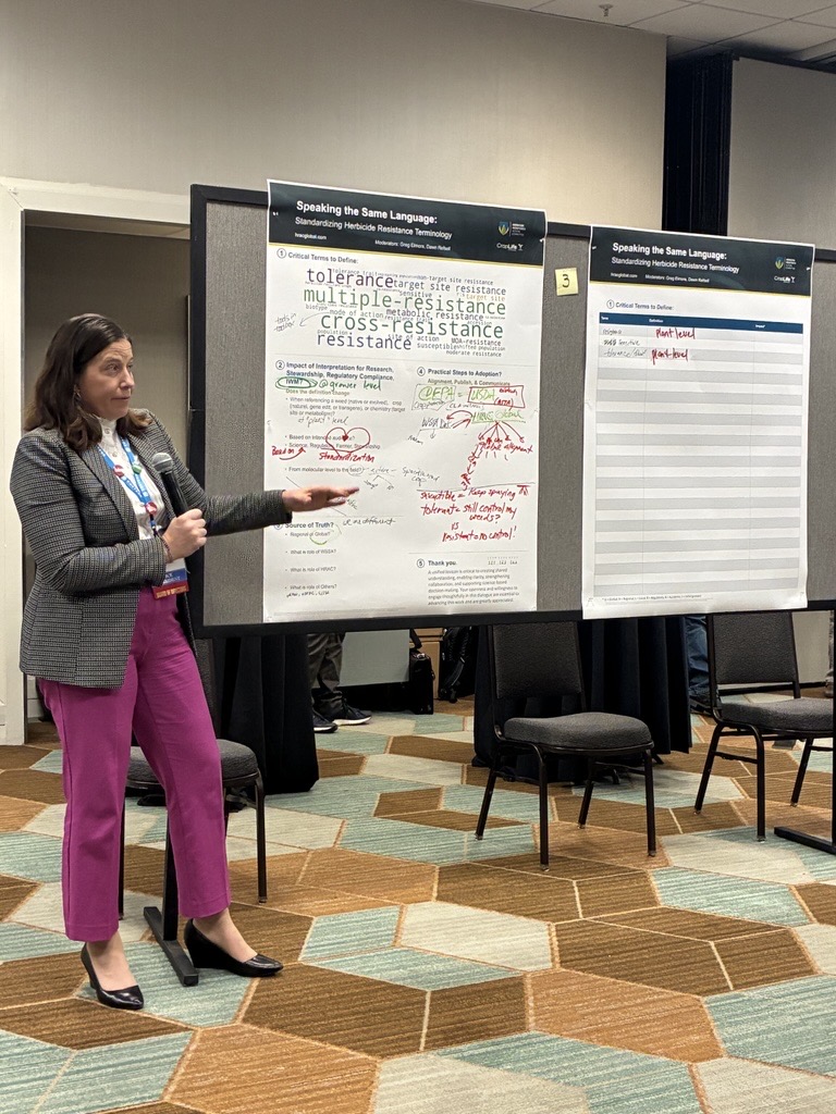 Conference speaker showcasing her poster presentation