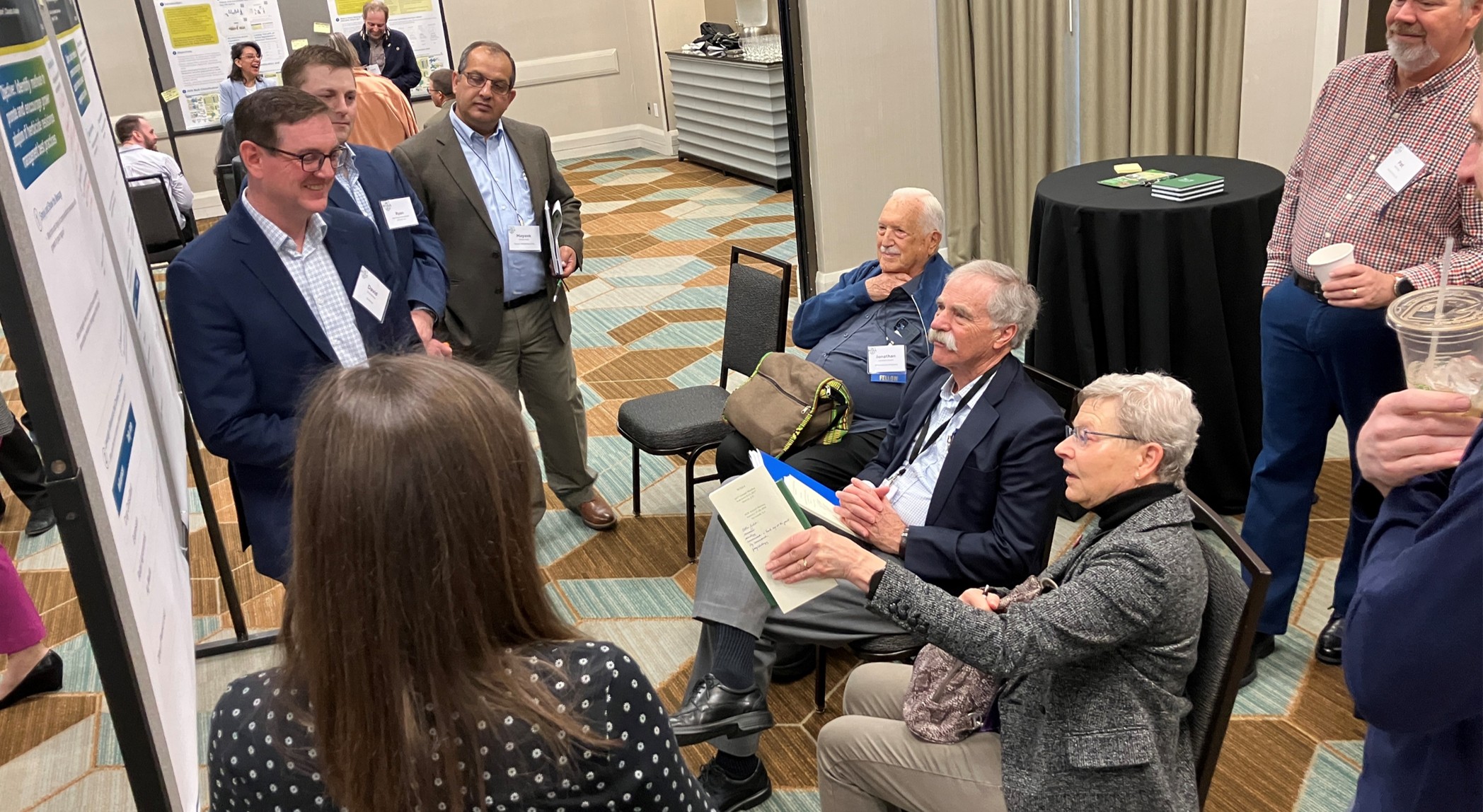 A breakout group discussing a poster presentation